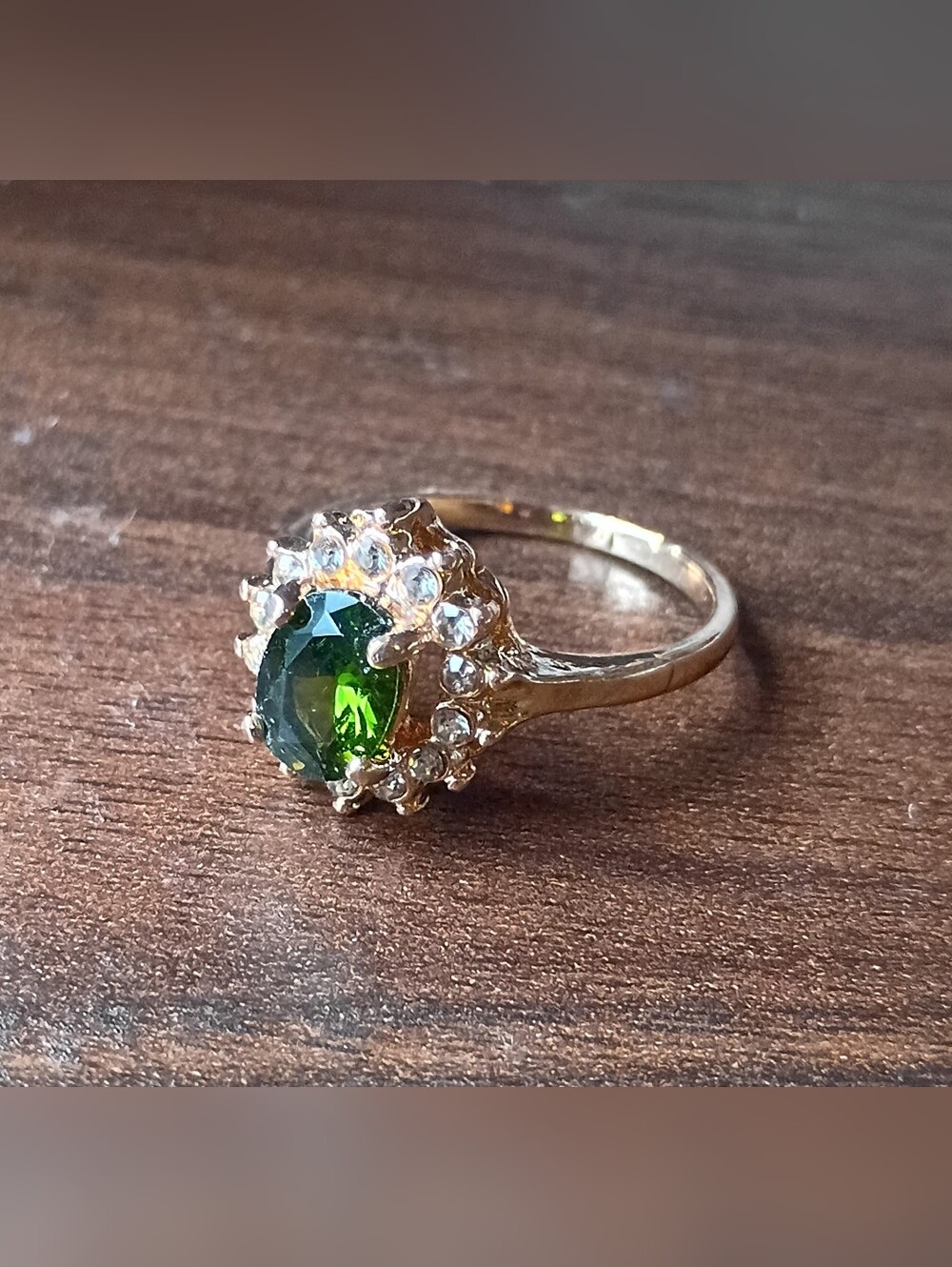 Gold Tone Gold Ring with Green Center Stone and Clear Accent Stones